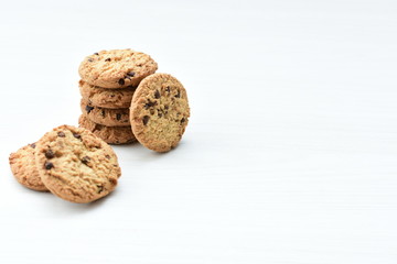 Oatmeal cookies and chocolate chips on light background