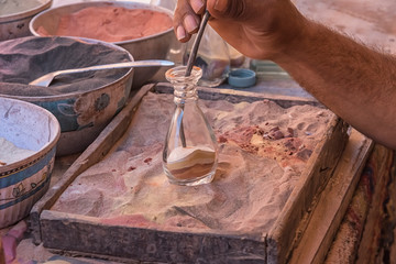 Making souvenirs from colored sand in Petra, Jordan. Life of the local population. Folk and traditional arts