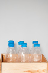 Plastic bottles with blue caps for recycling in a wooden box. Concept of Recycling plastic and ecology. Plastic waste. Stop nature garbage, ecology environment protection concept.