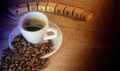 Colombian coffee cup on beans and dark background