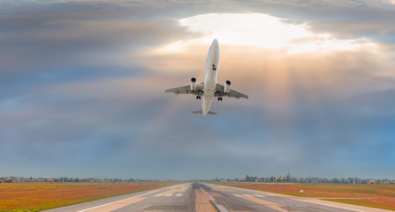 White Passenger plane fly up over take-off runway from airport 