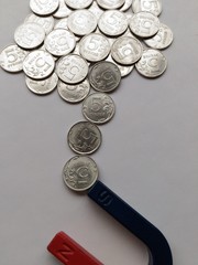 Coins are attracted by the action of a magnet.