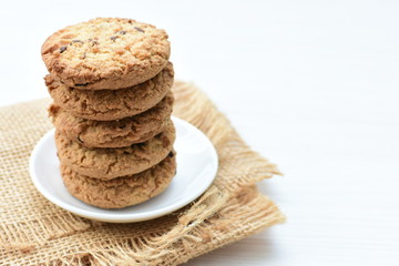 Fototapeta na wymiar Oatmeal cookies and chocolate chips on cloth background