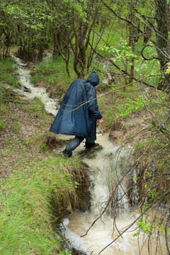 Peregrino bajo la lluvia cruzando un arroyo de camino a la localidad oscense de Ena en el Camino de Santiago Catal&aacute;n.