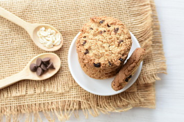 Oatmeal cookies and chocolate chips on cloth background