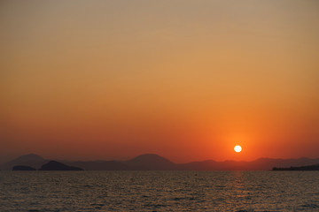 Sunset on the sandy beach with sea view. Seascape.