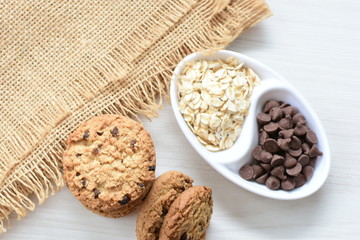 Oatmeal cookies and chocolate chips on cloth background