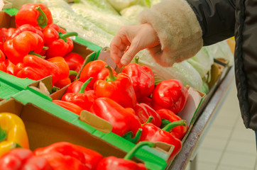 Red pepper on the counter buyer's hand