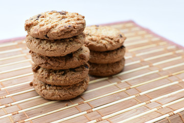 Oatmeal cookies and chocolate chips on light background