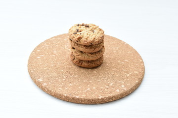 Oatmeal cookies and chocolate chips on light background