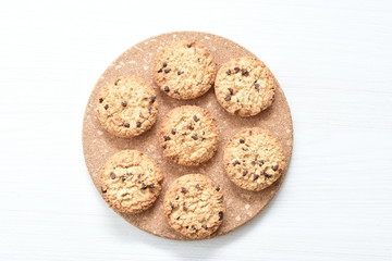 Oatmeal cookies and chocolate chips on light background