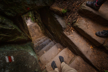 POV on Beautiful path with stairs steps carved in sandstone leading through old forest located in Czech Switzerland, Adrspach, Czechia