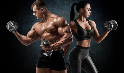 Fototapeta na wymiar Sporty couple workout with dumbbells. Muscular man and woman showing muscles