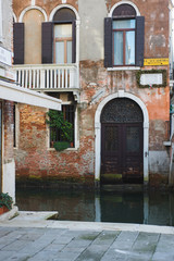 Beautiful historic brick buildings on the narrow streets and canals of the ancient city Venice.