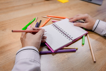 A picture of a business person holding a pen and taking notes in a notebook