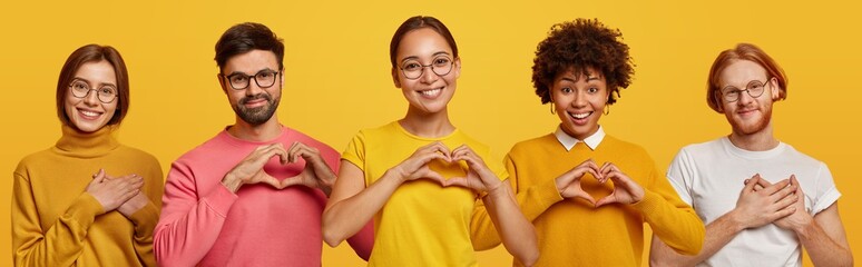 Horizontal shot of happy women and men show heart gesture, express love, say be my valentine, keep...