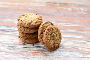 Oatmeal cookies and chocolate chips on light background