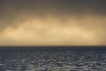 Fog and clouds hovering over the water.