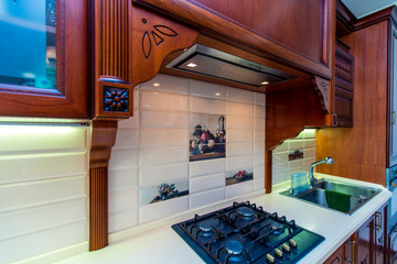 Antique wooden kitchen set made of mahogany. The furniture is covered with wood carvings. Gas...