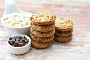 Oatmeal cookies and chocolate chips on light background