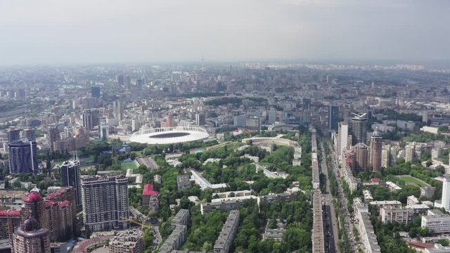 Stadium in a green city, a terrible sky and the sun's rays. Kyiv, Ukraine - Cityscape Aerial Flight