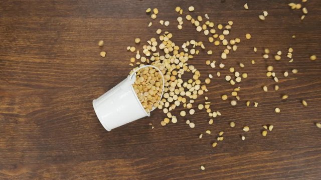 Falling of a full bucket with peas grains. Slow motion.