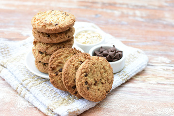 Oatmeal cookies and chocolate chips on light background
