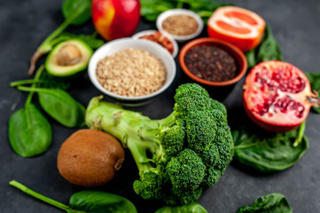  Selection of healthy food: fruits, seeds, cereals, superfoods, vegetables, leafy vegetables on a stone background. Healthy food for humans.