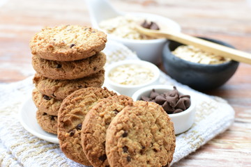 Fototapeta na wymiar Oatmeal cookies and chocolate chips on light background