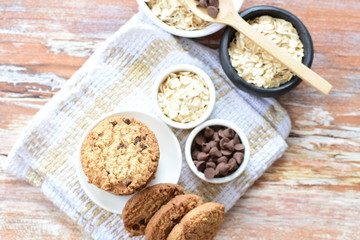 Oatmeal cookies and chocolate chips on light background