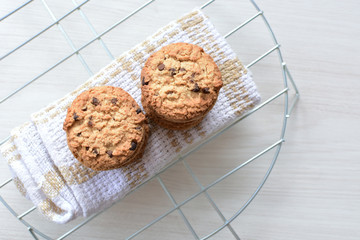 Oatmeal cookies and chocolate chips on light background