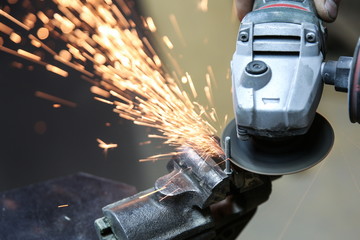 angle grinder is cutting metal with sparks close up