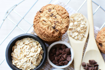 Oatmeal cookies and chocolate chips on light background