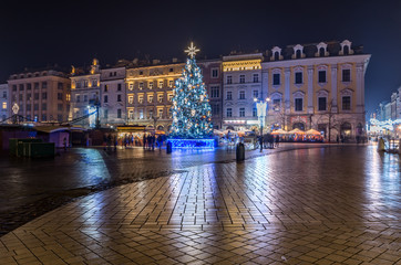 Naklejka premium Krakow, Poland, Main Square in the winter season, during Christmas fairs decorated with Christmas tree.
