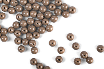 Large brown beads are scattered over a white isolated background