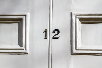 House number 12 on a white wooden front door