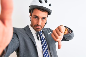 Young handsome business man wearing bike helmet taking a selfie over isolated background with angry...
