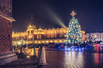 Fototapeta na wymiar Krakow, Poland, Main Square and Cloth Hall in the winter season, during Christmas fairs decorated with Christmas tree.