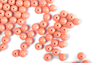 Large red beads are scattered on a white isolated background