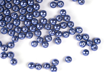Large blue beads are scattered on a white isolated background