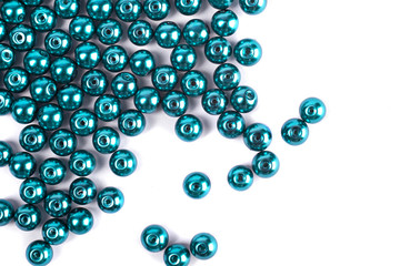 Large green beads are scattered on a white isolated background