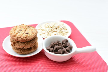 Oatmeal cookies and chocolate chips on colorful background
