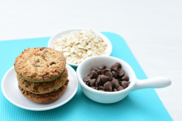 Oatmeal cookies and chocolate chips on colorful background