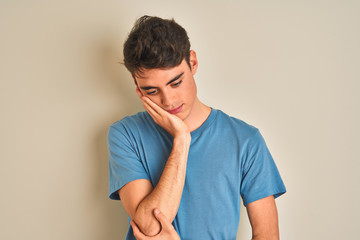 Teenager boy wearing casual t-shirt standing over isolated background thinking looking tired and...