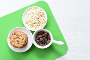 Oatmeal cookies and chocolate chips on colorful background