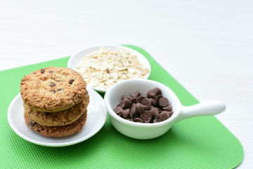 Oatmeal cookies and chocolate chips on colorful background