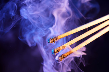 Lit matches and blown out in the studio photographed with colorful foils before the flashes