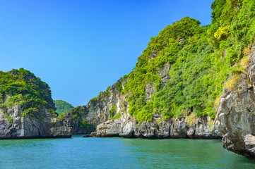 Halong bay islands. Tourist attraction, spectacular limestone grottos natural cave formations. Karst landforms in the sea, the world natural heritage. Beautiful azure water of the lagoon.