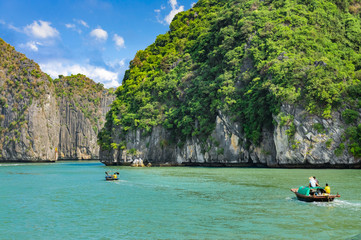 Fototapeta na wymiar Halong bay islands. Tourist attraction, spectacular limestone grottos natural cave formations. Karst landforms in the sea, the world natural heritage. Two boats sail