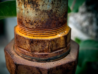 Colorful rusting industrial pipe outside of a building